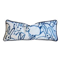 a blue and white pillow with rabbits on it