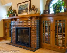 a living room with a fire place and bookshelves on top of the fireplace