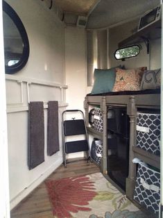 the inside of a camper with towels hanging on the wall and a chair in the doorway