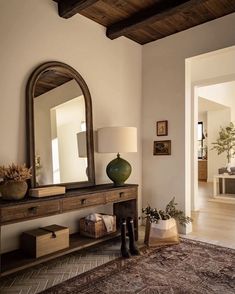 a living room filled with furniture and a large mirror on top of a wooden table