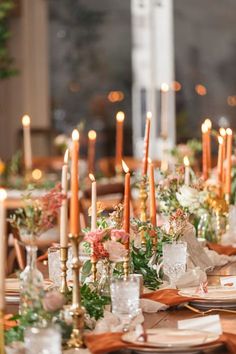 the table is set with many candles and place settings for an elegant dinner or party