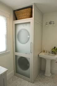 a bathroom with a washer and a sink in it's corner next to a window