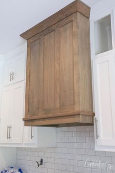 a kitchen with white and wood cabinets and tile backsplashes on the wall