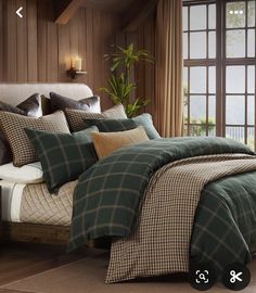 a bed with green and brown plaid comforter in a bedroom next to a window