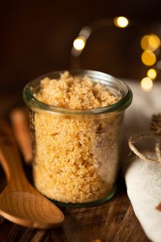 a glass jar filled with sugar next to a wooden spoon