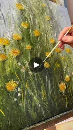 someone is painting yellow flowers on an easel