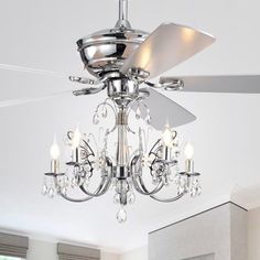 a ceiling fan that is hanging from the ceiling in a room with white walls and windows