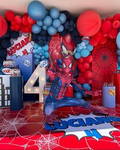 a spiderman themed birthday party with balloons and decorations