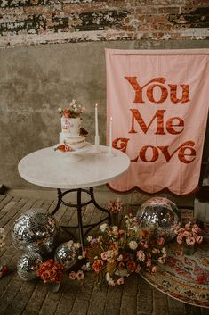 a table with a cake on it next to a sign that says you me and love