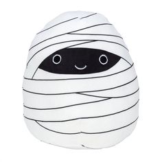 a white stuffed animal with black stripes on it's face and eyes, wrapped in a blanket