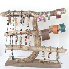 a sculpture made out of driftwood with beads and bracelets hanging from it's sides