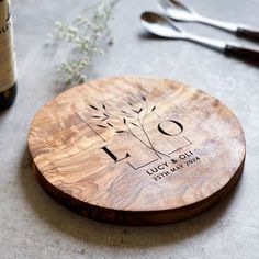 a personalized cutting board on a table with utensils and wine bottle in the background