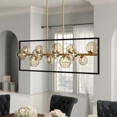 a dining room table with chairs and a chandelier hanging from the ceiling over it