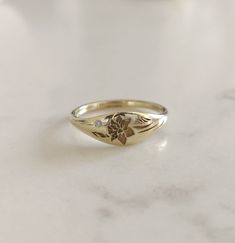 Elegant and unique 14k gold Daffodil signet ring, Vintage style floral wedding band, unique gold wedding ring for the stylish bride to be set with a tiny diamond.  * Band width: 1.5 mm, wide part width: 5.5 mm * Thickness: 1.5 mm * Embedded with a one round 1 mm diamond, VS1 F.  * Available in 14K or 18K YELLOW, WHITE and ROSE gold.    The price listed is for 14K please contact me for 18K pricing. * available with darkend flower ( please mention in note to seller)  * Sizes vary from 5 US to 9 US Signet Ring Wedding Band, Signate Ring, Lavender Wedding Ring, Lavender Ring, Textured Wedding Band