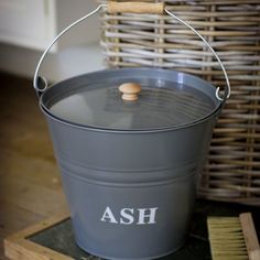 an ash bucket sitting on top of a wooden floor