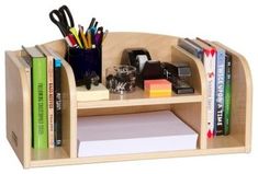 a wooden desk with books, pens and other office supplies on top of the shelf