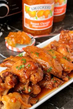 chicken wings covered in sauce and garnished with parsley on a white plate