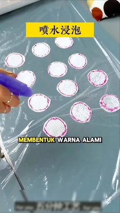 someone is cutting circles with scissors on a sheet of clear plastic and writing in chinese