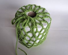 a green crocheted object on a white surface