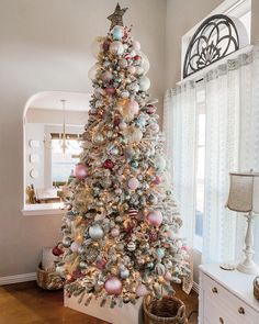 a decorated christmas tree in a living room with lots of ornaments on the top and bottom