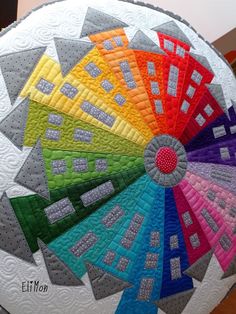 a colorful quilt on top of a large white object with multiple colors in the center