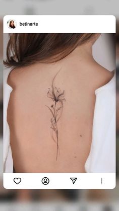 the back of a woman's neck with a flower tattoo on her left shoulder