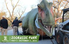 an inflatable dinosaur is on the back of a truck as people look at it