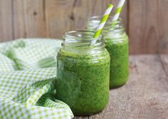 a green smoothie is in a glass pitcher