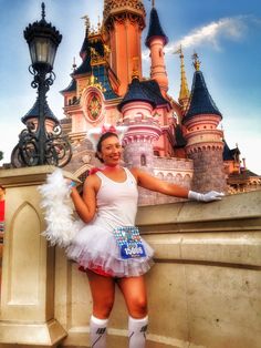 a woman is posing in front of a castle