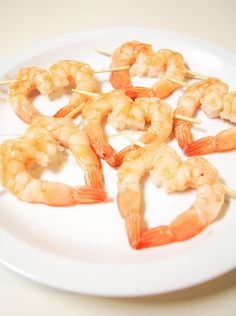 shrimp skewers are arranged on a white plate