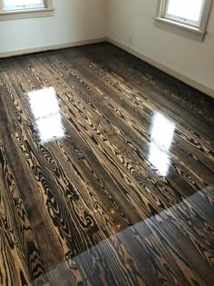 an empty room with wood floors and windows