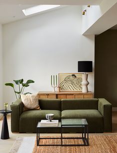 a living room filled with furniture and a painting on the wall next to a coffee table