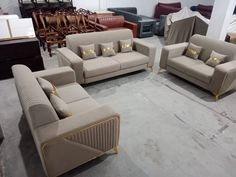 a group of couches and chairs in a room with other furniture on the floor