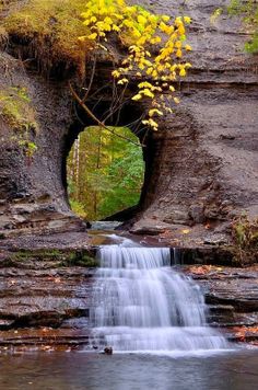 a small waterfall is coming out of a cave