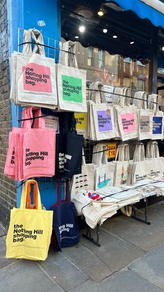 bags and totes are on display in front of a store