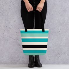 Discover elegance and functionality with our Stylish Horizon Striped Tote Bag. This tote combines bold teal, light blue, black, and white stripes in a minimalist palette, perfect for everyday use or as a statement piece. Crafted from 100% spun polyester fabric, this tote is not only durable but also lightweight. It boasts a spacious size of 15″ × 15″ (38.1 × 38.1 cm) with a capacity of 2.6 US gallons (10 liters), ensuring ample room for all your essentials. Whether you're heading to the beach, grocery shopping, or running errands, this tote can comfortably carry up to 44lbs (20 kg). Designed for practicality, it features dual handles made from 100% natural cotton bull denim, offering a comfortable grip with a handle length of 11.8″ (30 cm) and a width of 1″ (2.5 cm). Key Features: - Bold t Modern Turquoise Bag For Everyday Use, Cheap Turquoise Tote Bag, Large Capacity Rectangular Striped Bag, Modern Striped Tote Bag, Blue Rectangular Canvas Bag For On-the-go, Black And White Rectangular Shopping Bag, Teal Tote Bag, Trendy Tote, Black Tote Bag