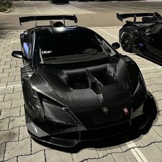 two black sports cars parked next to each other