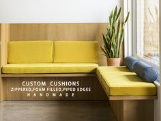 a yellow couch sitting on top of a wooden bench next to a potted plant