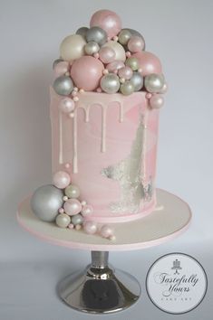 a pink cake with white and silver decorations