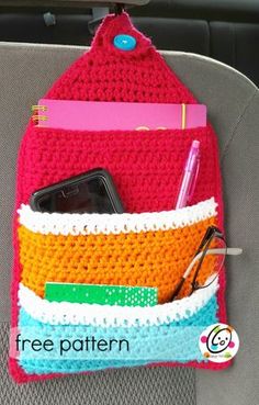 a cell phone in a crocheted purse on the back seat of a car