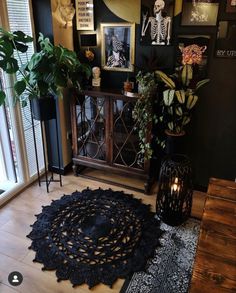 a living room filled with lots of furniture and plants on top of a wooden floor