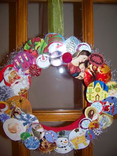 a christmas wreath made out of buttons and tinsel on a window sill in front of a wooden frame