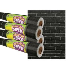 3 rolls of better than paper on top of a brick wall