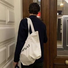 a person standing in front of a door with a white bag on their back,