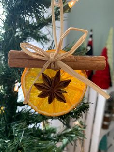 an ornament hanging from a christmas tree decorated with cinnamon and star anise