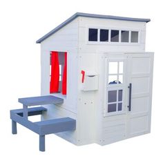 a white doll house with red doors and windows