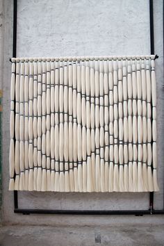 a large piece of art made out of toothpicks on a metal rack in front of a white wall