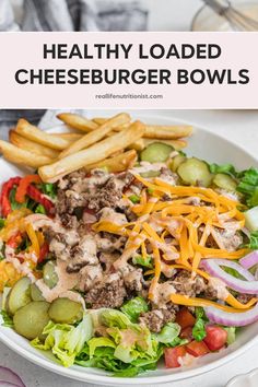 healthy loaded cheeseburger bowls in a white bowl with fries and salad on the side