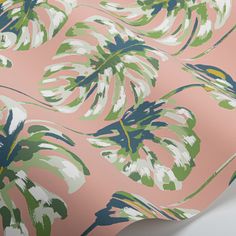 a pink and green tropical print wallpaper with palm leaves on the side, in an angled view