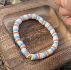 a person holding onto a bracelet with multicolored beads